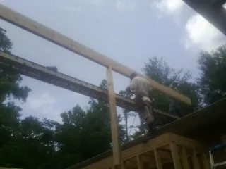 Carpenter setting a ridge beam over a new addition frame — Ice Dam Removal by Roofing Brothers in Thomasville