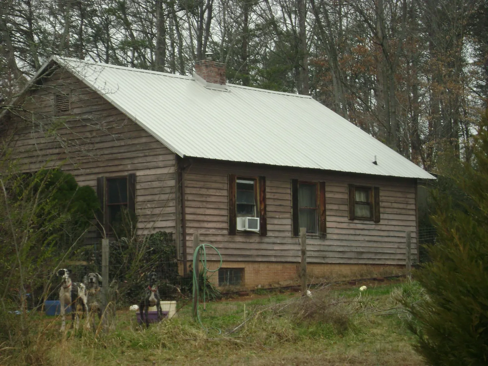 White metal roof on an old wood sided farmhouse, from a Metal Roof Installation job in Thomasville